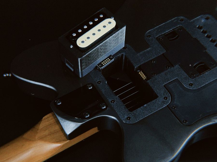 實機拍攝——humbucker 卡匣立於琴身卡匣槽上方，暗場側光